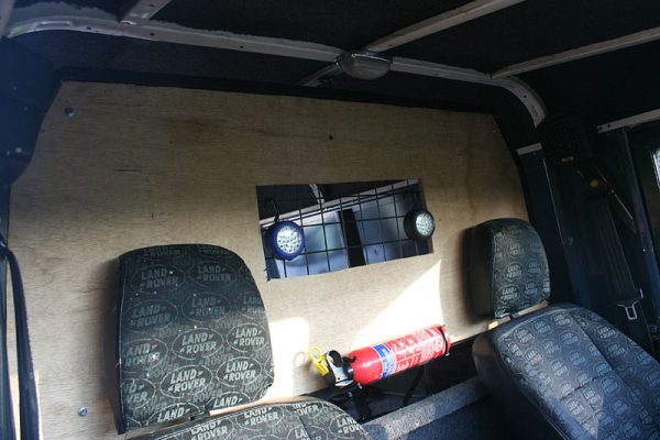Cut a hole in the wood to allow use of the rear view mirror