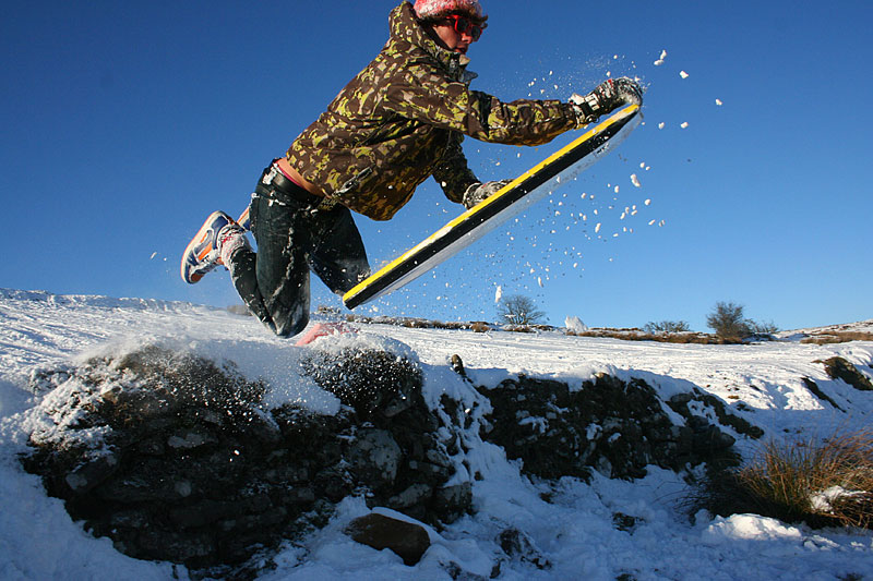 Having fun in the snow on an old bodyboard