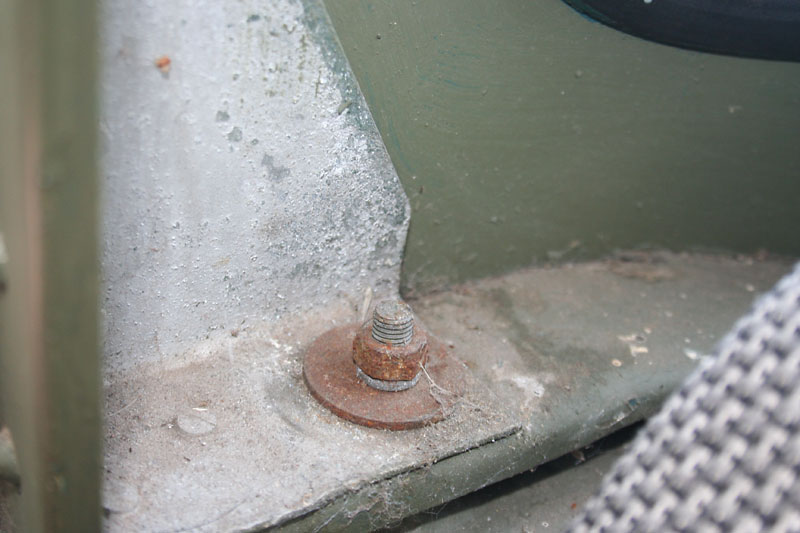 The long bolt just behind the driver and passenger seat